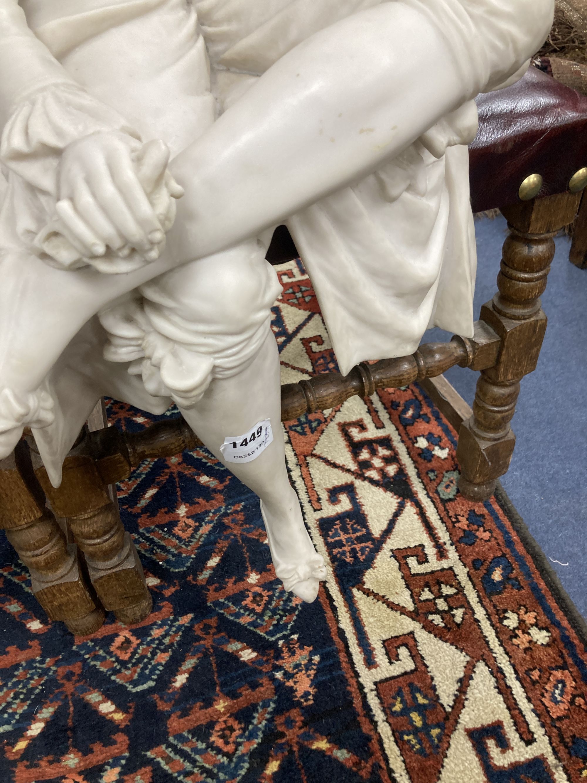 A pair of resin marble seated figures of a Dandy and a Dandizette on ebonised plinths